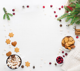 Christmas decoration, cup of coffee, homemade sweet gingerbread cookies, pine cones and branches on white wooden background.