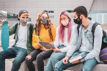Multiethnic students sitting with mask  on the bench together in a university - Group of young...
