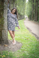 Mixed Race, Plus Sized Model Posing Against Tree In Park