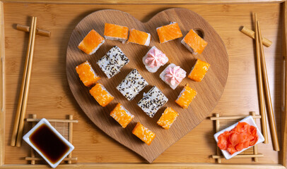 sushi rolls on a wooden background in the form of a heart. concept February 14, love Valentines day