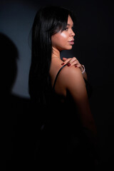 Naklejka premium beautiful girl in black on dark background.
