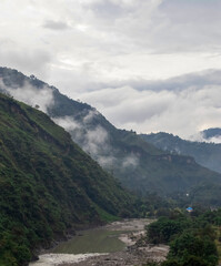 Green mountains with clouds over them