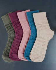 different colored women's socks on a dark wooden background. Lot of socks.