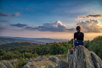 A young girl enjoys a beautiful view from top .Travel in the mountains.