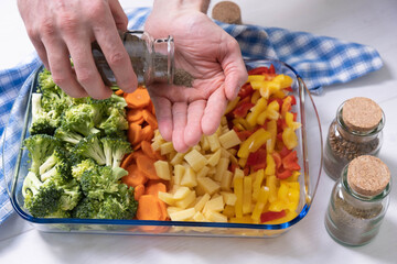 hands hold a jar of spices for adding to vegetable dishes