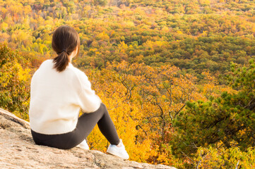 person sitting on a tree in autumn