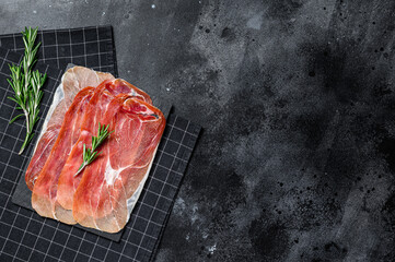 prosciutto crudo, italian salami, parma ham. Antipasto plate. Black background, top view, space for text