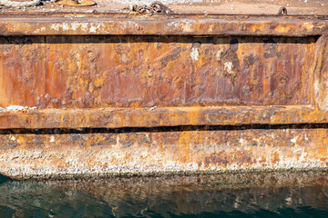 Rusty metal old industrial harbor quay, reflections on the water