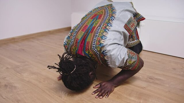 Black muslim man praying at home with dedication