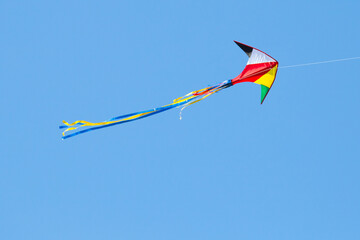 kite on the blue sky in sunny weather and wind. Kite flying in summer with copy space. Liberty.