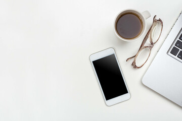 wooden table with modern mobile phone computer keyboard, coffee cup and glasses. mock up, empty...