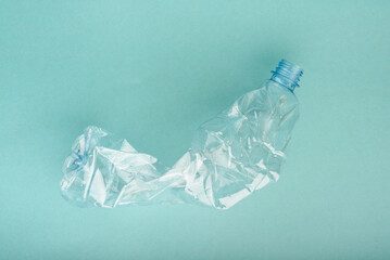 Used crushed plastic bottle on the blue background. Recycling concept.