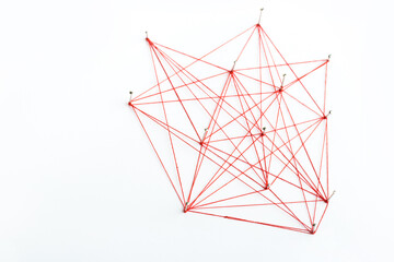 A large mesh of pins tied together with a red cord. Communication, network concept.
