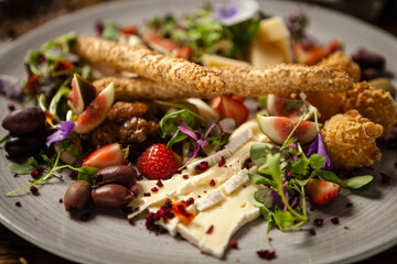 Cheese platter for two: Goat cheese cream, gorgonzola, camembert, grissini and fig jam. Delicious healthy Italian traditional food closeup served for lunch in modern gourmet cuisine restaurant