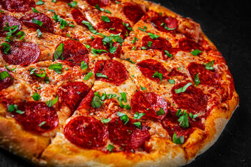 Pepperoni Pizza with Mozzarella cheese, salami, Tomato sauce, pepper, Spices. Italian pizza on Dark grey black slate background