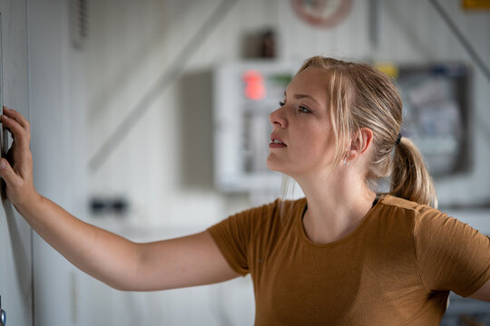 Technisierung in der Landwirtschaft - junge Landwirtin kontrolliert die Steuerung einer Biogasanlage, Symbolfoto.