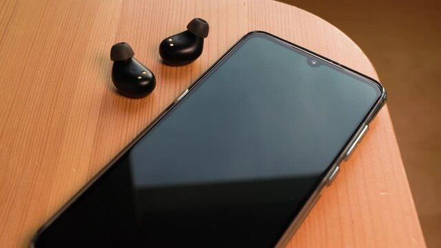 UWB or ultra wireband radio technology Wireless earphones connecting to a smartphone. Zoom