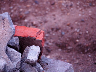 Fototapeta premium red brick with pieces of gray concrete with gravel in the background, construction waste, construction site, ruins,