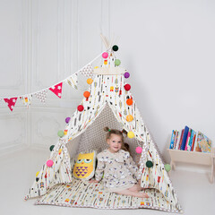 a little girl playing in a teepee © Alexander