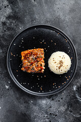 Japanese Teriyaki grilled salmon fillet glazed in delicious sauce with a side dish of rice. Black background. Top view