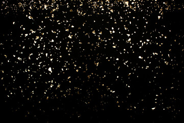 Naklejka na ściany i meble Festive luxury black background with holographic flying golden sparkles for your project. Holiday backdrop with copyspace. Birthday party, Christmas and New Year celebration concept