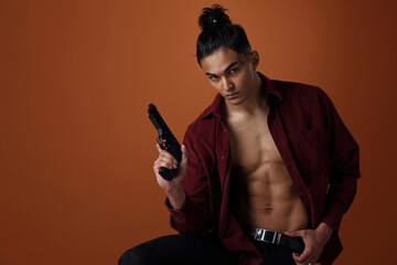 A man of Asian appearance with a gun in his hands