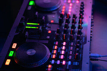 Mesa controladora de sonido con auriculares de DJ encendida con colores morados y azules