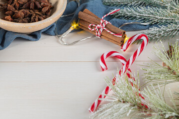 Bright Christmas or New Year wooden background with fir branches, Christmas decorations. Christmas sweets. Copy space. View from above