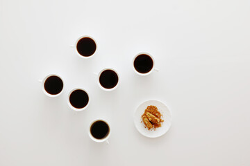 Kaffeetassen mit Keksen auf weißem Tisch