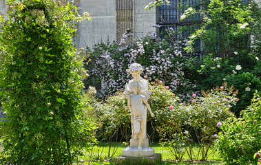 Statue of Elves in White Rose Garden with Trellis