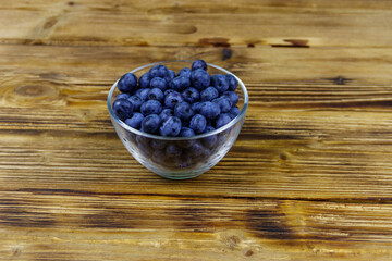 Fresh blueberry in glass bowl on a wooden table