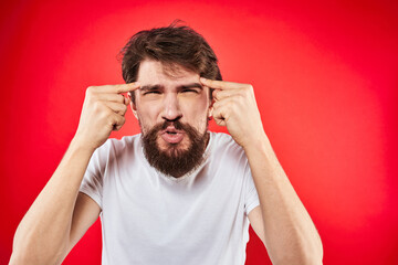 Fototapeta premium bearded man gesturing with hands white t-shirt emotions facial expression aggression red isolated background