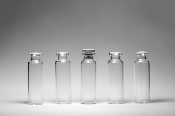 medical bottles test tubes black and white photo stand on a gray background five in a row transparent glass containers for medicine