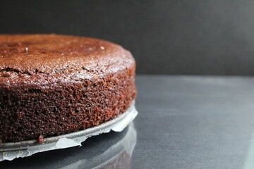 background food dark chocolate brownie pie close up with cracks baking side view on black dark background with copy space for text