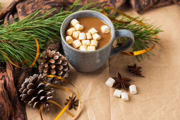Fototapeta na wymiar A Cup of coffee or cocoa with marshmallows with Christmas tree or New year decor. Winter still life with a warm drink, scarf, anise stars and cones