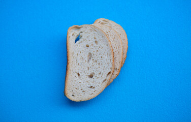 Three slices of white wheat bread on a blue background, front view.