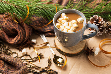 A Cup of coffee or cocoa with marshmallows with Christmas tree or New year  decor. Winter still life with a warm drink, scarf, anise stars and cones