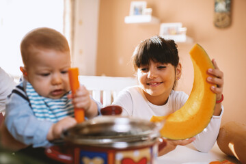 Young mother and children preparing meal with healthy food