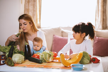 Young mother and children preparing meal with healthy food