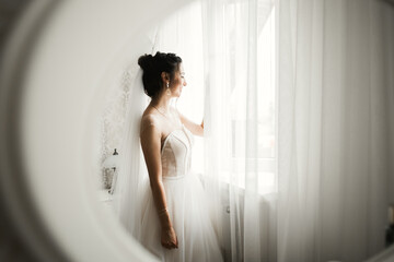 Gorgeous bride in robe posing and preparing for the wedding ceremony face in a room