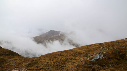 High up in the Austrian Alps in foggy weather on overcast day