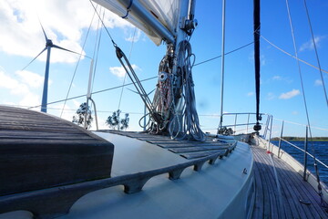 Deck of a sailing yacht with windmills in the background with a beautiful clouded sky above. © Paula Stock