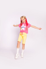Fototapeta na wymiar cute girl in bright colorful clothes and with colored braids
