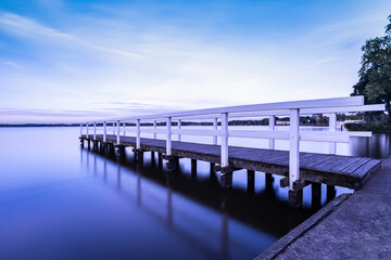 Fototapeta na wymiar footbridge in the lake, reflection at sunset, Zwischenahner Meer
