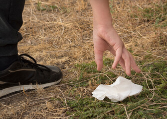 Мan's hand picks up the trash