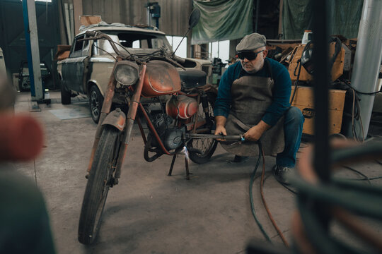Mechanic works a vintage motorcycle in the workshop