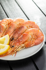 Boiled tiger prawns with lemon on plate. Tasty shrimps.