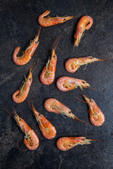 Boiled tiger prawns on black table. Tasty shrimps.