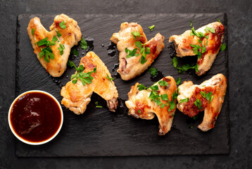 grilled chicken wings with sauce on stone background. selective focus