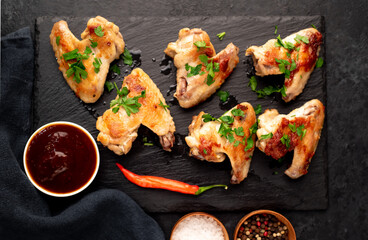 grilled chicken wings with sauce on stone background. selective focus